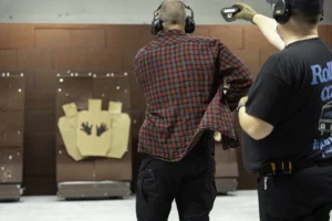 IDPA-harrastaja vetää paidan alta pistoolia kotelostaan ampuakseen rastisuorituksen.